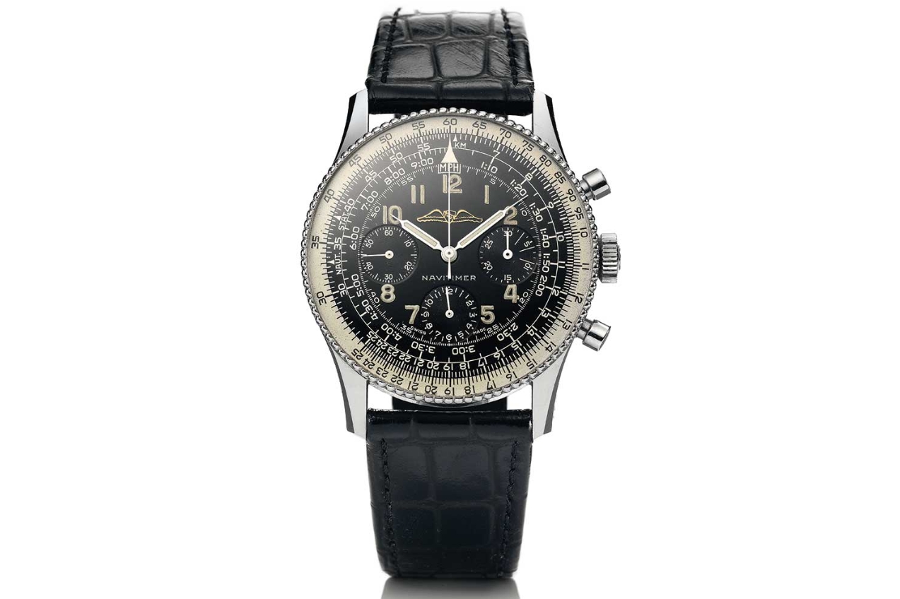 Front view of a black dial Navitimer style chronograph on a black strap