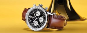 Breitling Navitimer B09 style chronograph with brown strap beside a trumpet